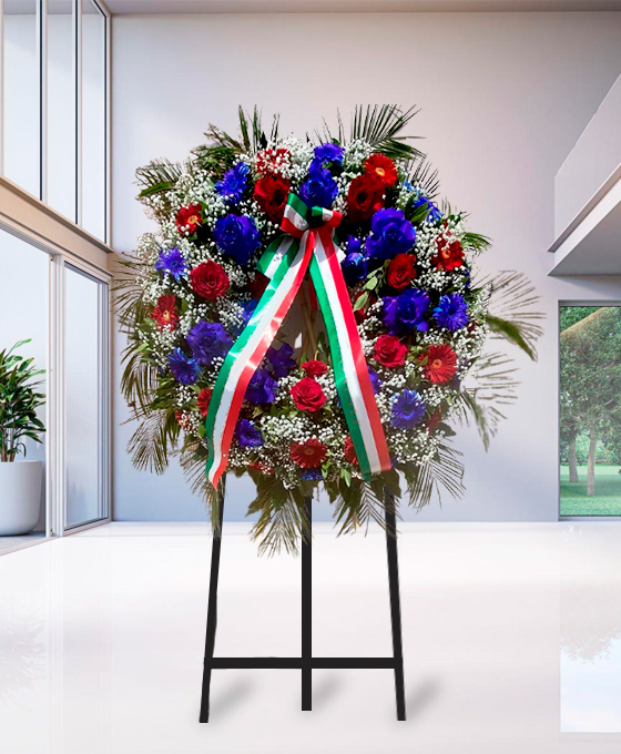 Corona funebre di rose rosse e blu, su cavalletto, per una cerimonia a Bologna