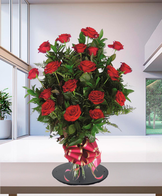Mazzo funebre di rose rosse con verde di felce e fiocco rosso alla base