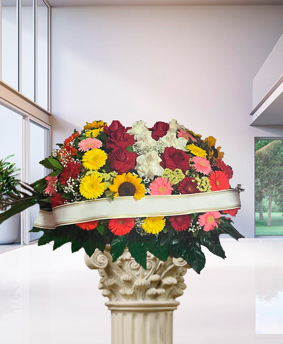 Cuscino funebre misto con girasoli e rose, composizione su sostegno per una cerimonia a Bologna