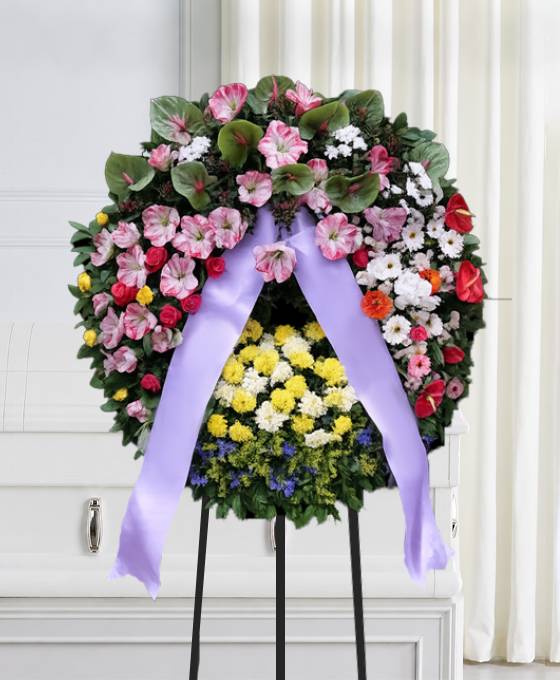 Corona funebre di amarillis anthurium e fiori in armonia con nastro, composizione per un funerale a Bologna