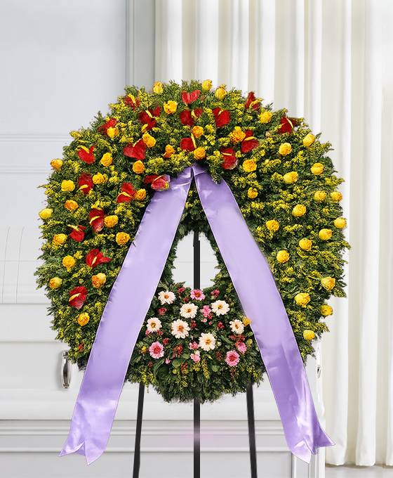 Corona funebre di fiori con colori in armonia con nastro, composizione per un funerale a Bologna