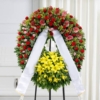 Corona funebre con fiori di stagione dai colori caldi, su cavalletto, per una cerimonia a Bologna