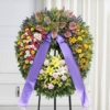 Corona funebre con fiori di stagione montata su cavalletto, omaggio floreale a Bologna