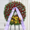Corona funebre di rose, lisianthus bianco e gerbera gialla con nastro, composizione per un funerale a Bologna