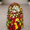 Cofano funebre con fiori di primavera disteso sul feretro, omaggio floreale a Bologna