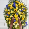 Cuscino funebre di fiori gialli e blu, composizione su sostegno per una cerimonia a Bologna