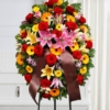 Cuscino funebre di fiori dai toni caldi, omaggio floreale da collocare accanto al feretro