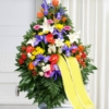 Cesto funebre di fiori colorati, omaggio floreale che si appoggia su un piano