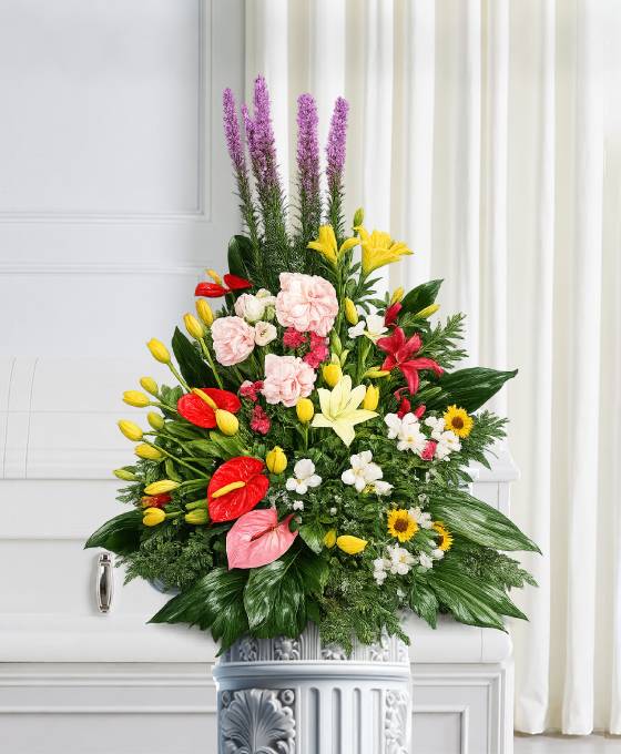 Cesto funebre misto con anthurium, garofani, gigli e fiori a spiga di diverse altezze