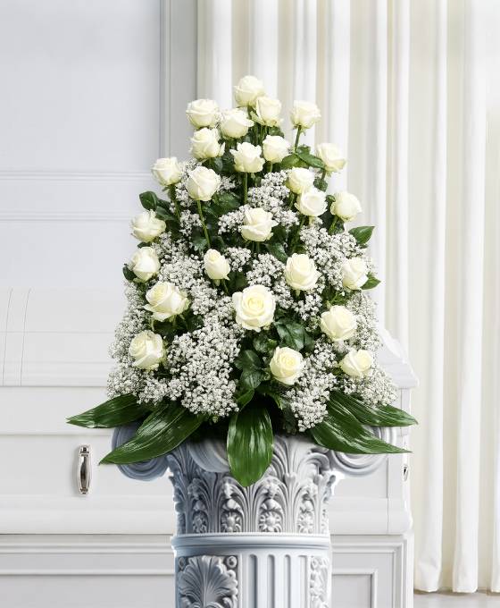 Cesto funebre di rose bianche con gipsofila e base di aspidistra, composizione triangolare