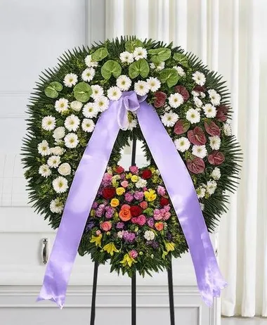 Corona funebre con crisantemi bianchi, fiori misti e nastro lilla