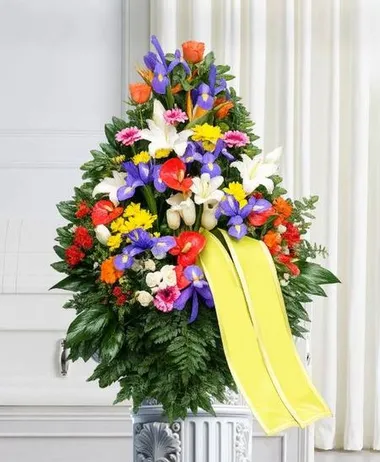 Composizione floreale funebre colorata con iris e fiori misti